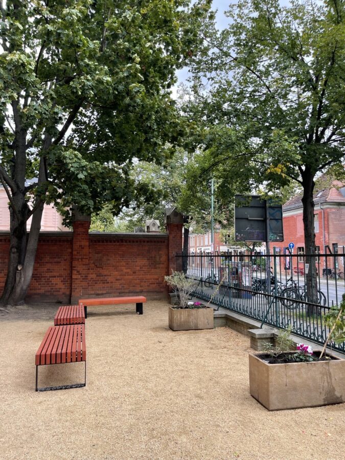 Ein Foto des Schulhofs des Potsdamer Helmholtz-Gymnasiums: nach der Verschönerungsmaßnahme befinden sich nun zwei Beete und einige Sitzbänke auf dem Areal