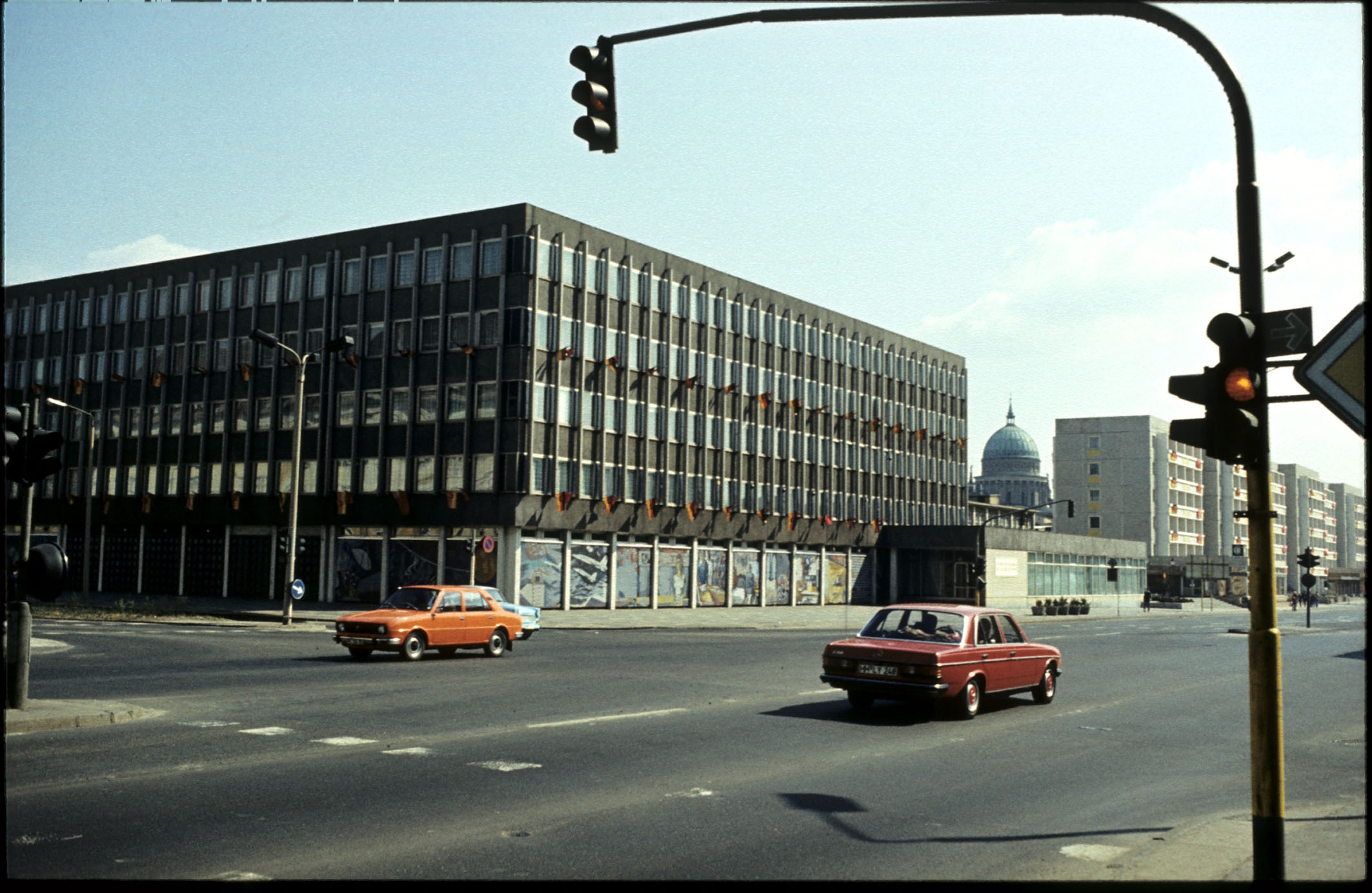 Ein historisches Foto des Rechenzentrums, bei dem im Vordergrund eine mehrspurige Straße und eine Ampel zu sehen sind. Vor dem Gebäude sind zwei Autos und Lampen im Stil der späten DDR. Das Rechenzentrum hat eine dunklere Fassade als heute, zudem sind noch die Lisenen an der Außenhaut befestigt. Vor den Studentenwohnheimen ist das Kantinengebäude, auch Sozialtrakt genannt, zu sehen.